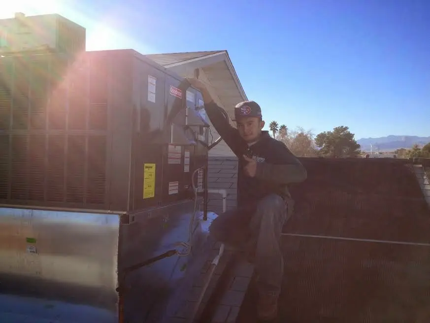 HVAC technician performing Air Duct Repair on a rooftop unit in Sparks